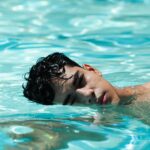 a young man swimming in a pool of water