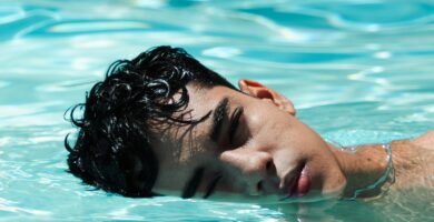 a young man swimming in a pool of water